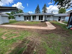 A house with a concrete walkway in front of it.