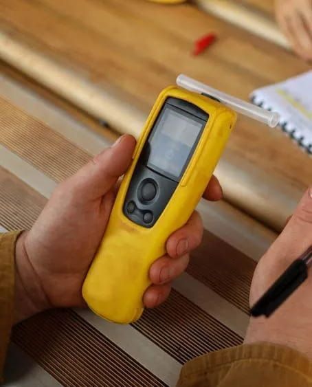 A Person is Holding a Yellow Breathalyzer in Their Hand — Fosters Ace Auto Repairs In Aitkenvale, QLD
