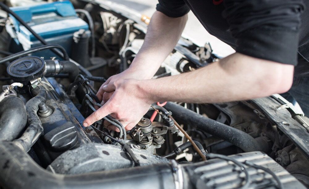 A Man is Working on the Engine of a Car — Fosters Ace Auto Repairs In Aitkenvale, QLD