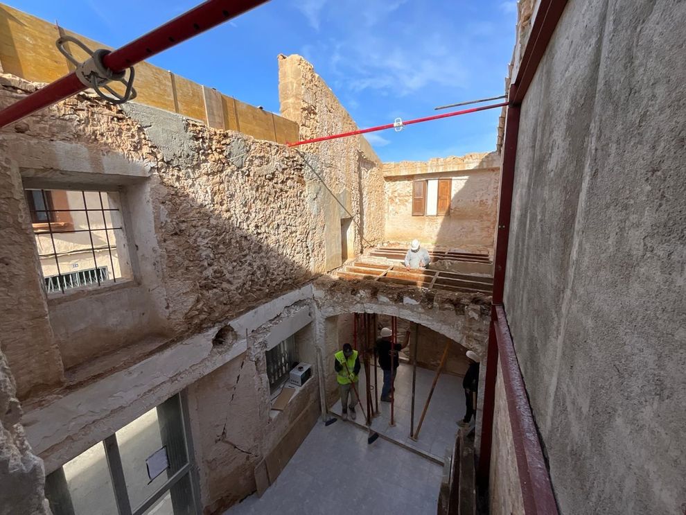 Interior de un edificio en obras con obreros de CAN RAMIS  trabajando. 