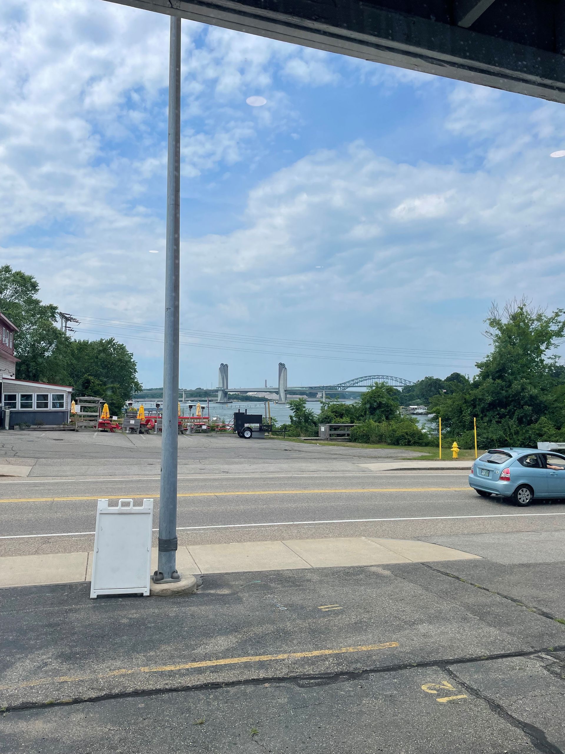 A car is parked in a parking lot next to a pole