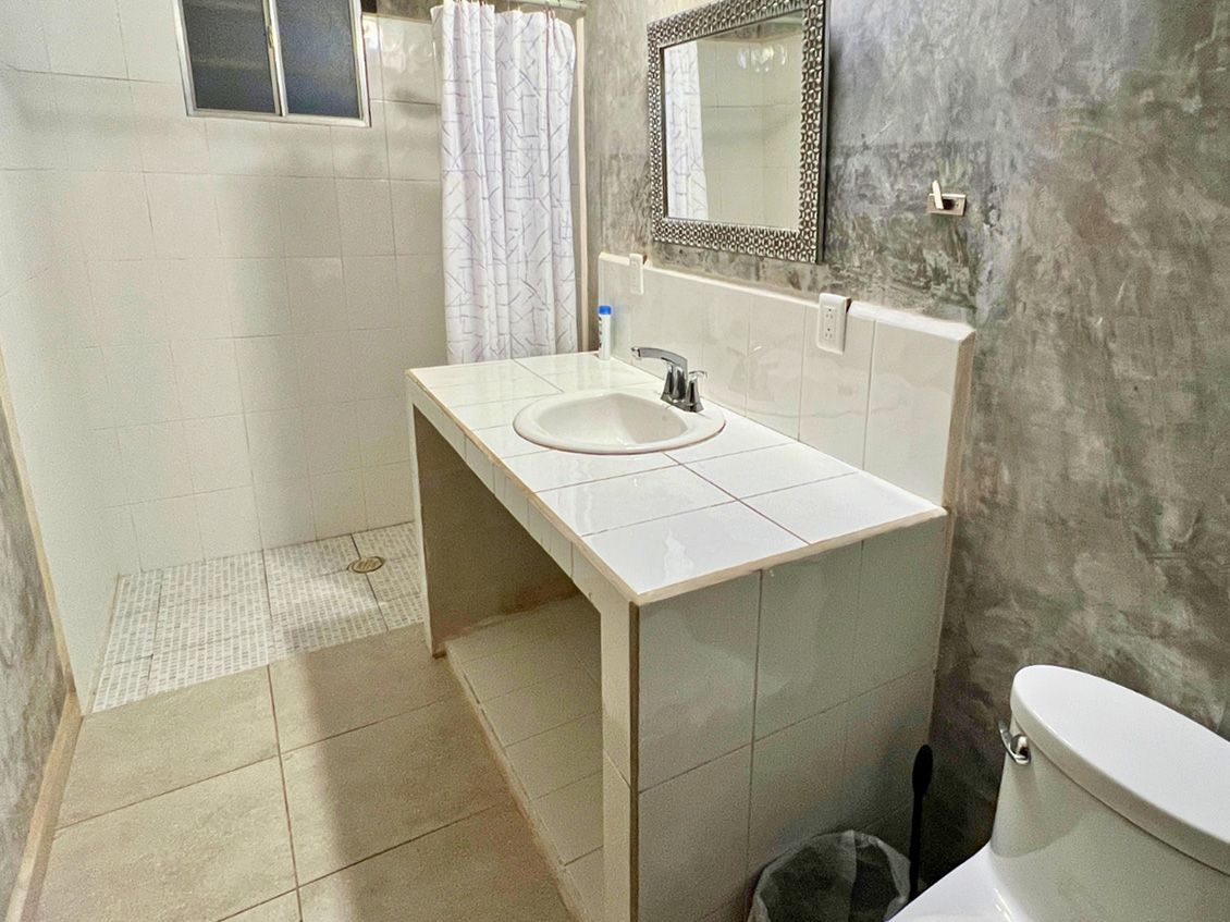 A bathroom with a sink , toilet and mirror.