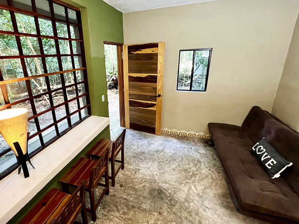 A living room with a couch and stools and a pillow that says love