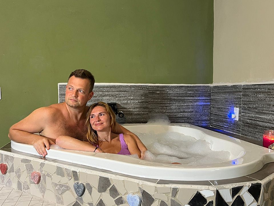 A man and a woman are sitting in a jacuzzi tub.