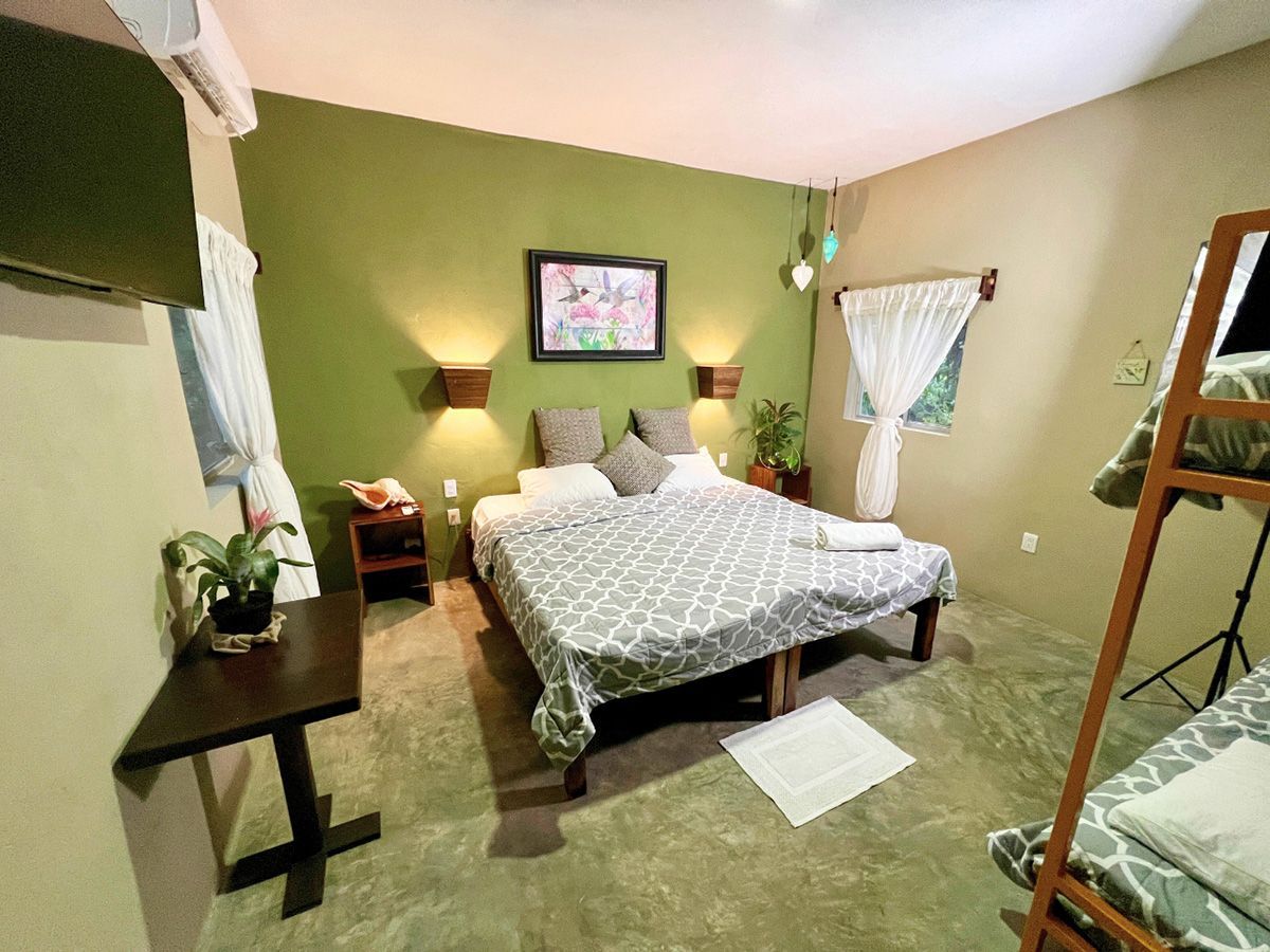 A hotel room with two beds and a bunk bed.