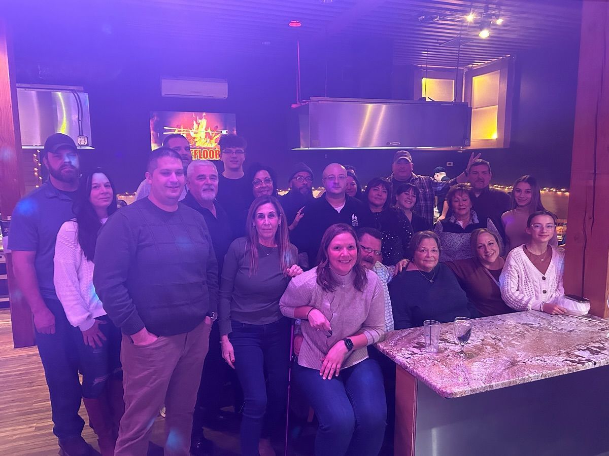 A large group of people are posing for a picture at desaki Restaurant
