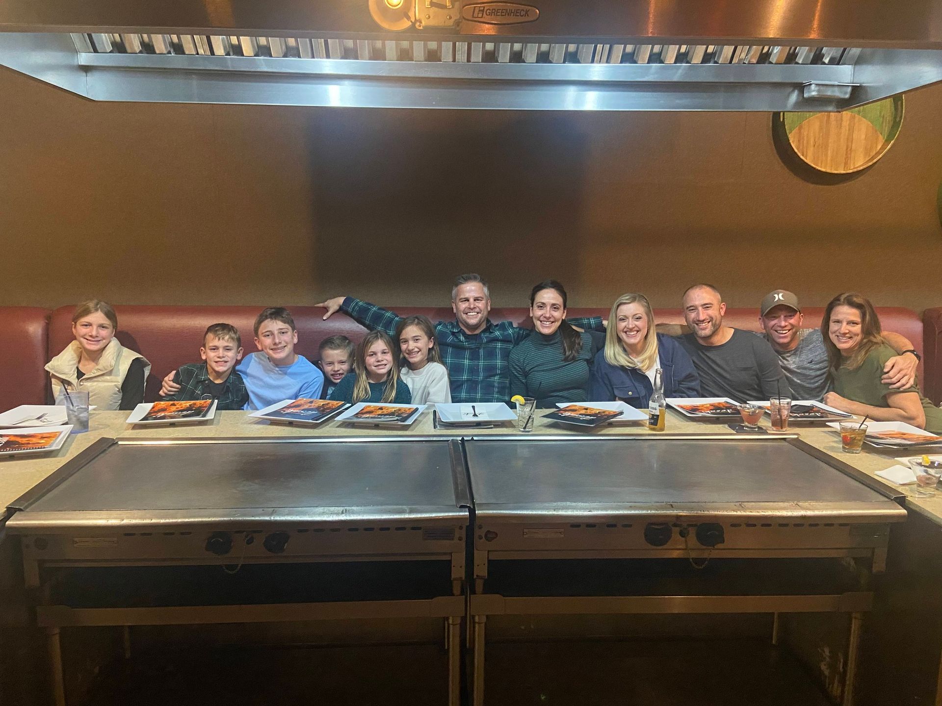 A group of people are posing for a picture in desaki Restaurant.