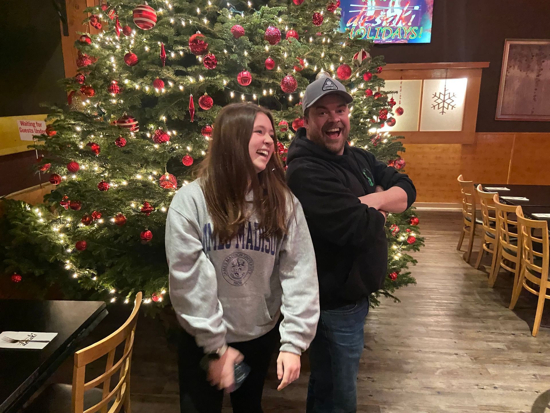 Father and Daughter in front of Christmas Tree laughing at desaki