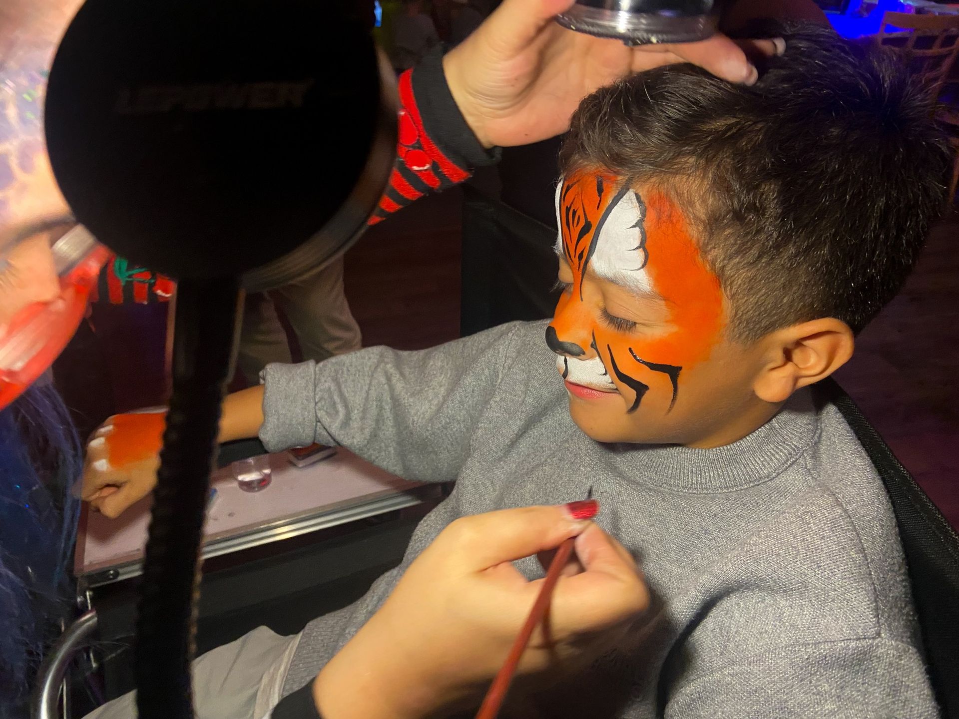 A young boy has his face painted like a tiger at desaki