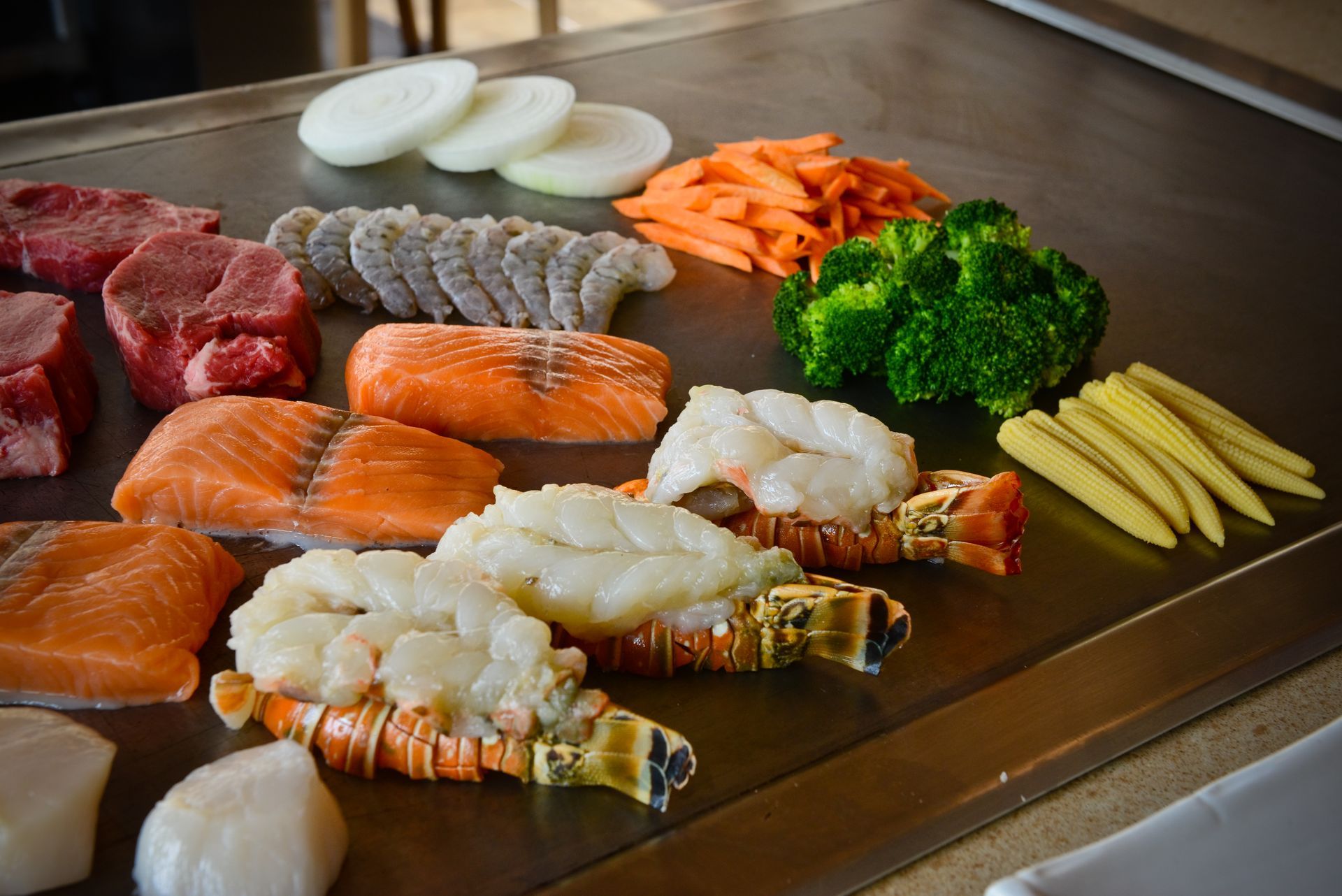 Lobster, salmon, filet, shrimp, and veggies on the hibachi grill at desaki Restaurant