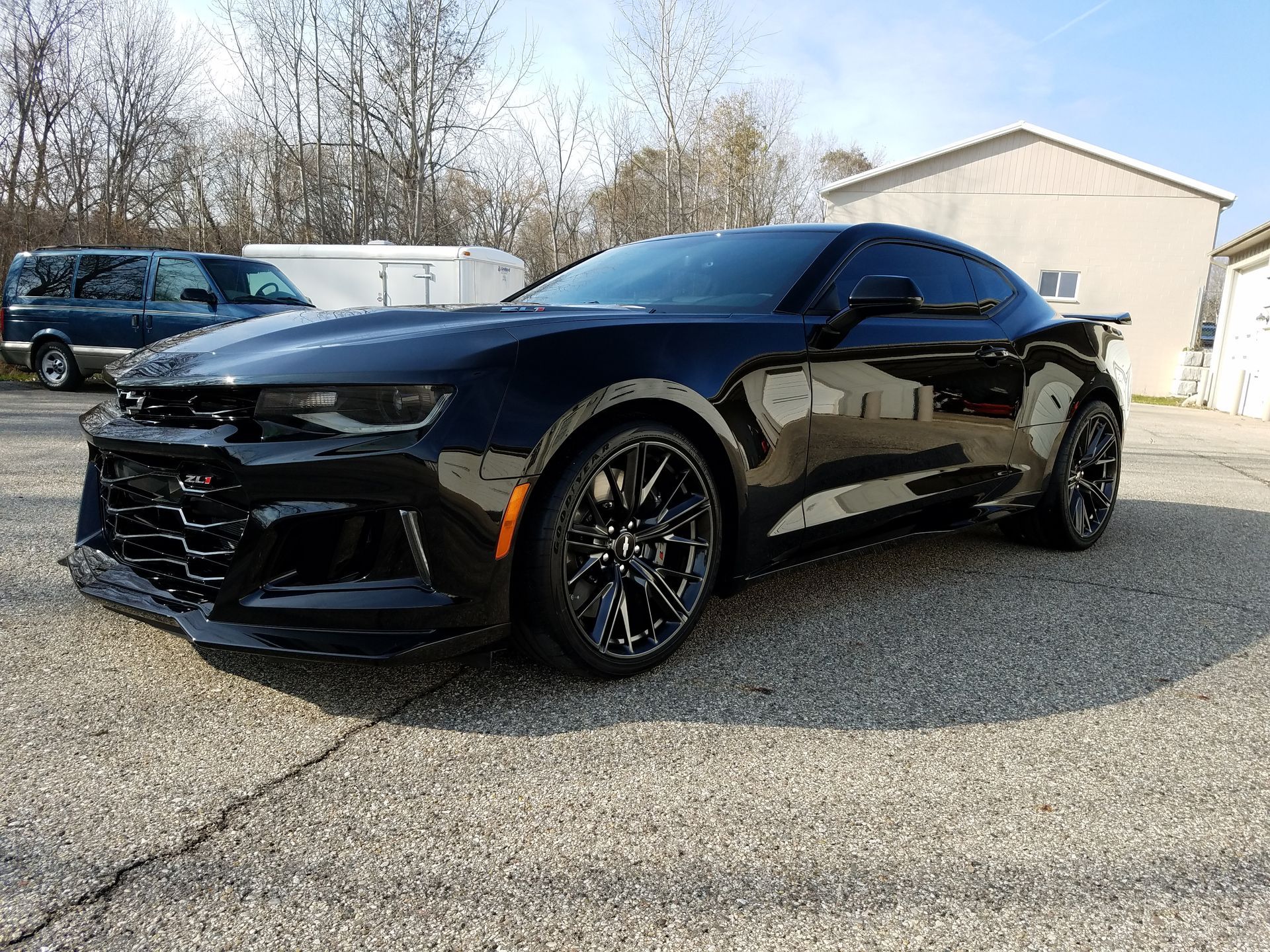 A black chevrolet camaro zl1 is parked in a parking lot.