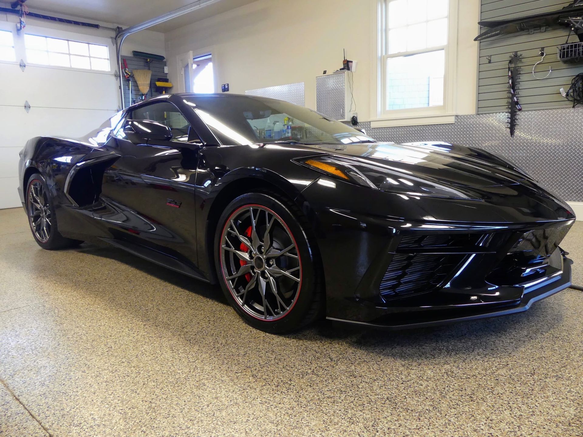 A black sports car is parked in a garage.