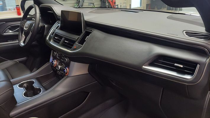 The interior of a car with a dashboard and steering wheel