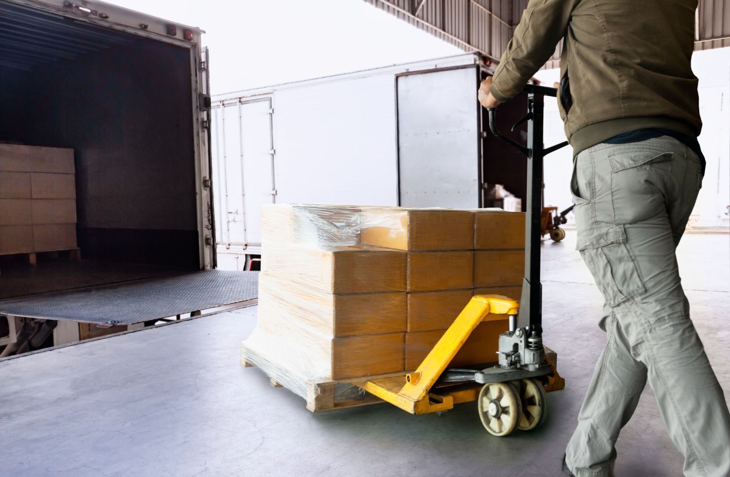A man loading a pallet onto a truck