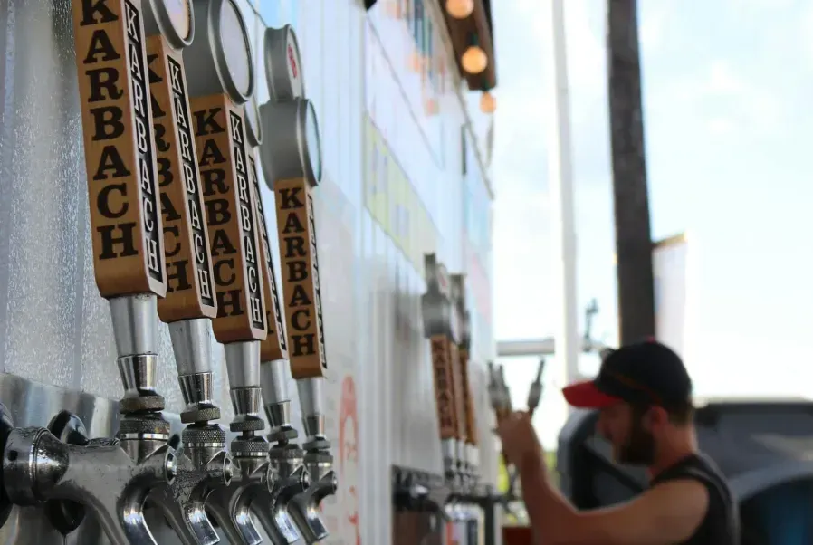 Three children wearing sunglasses posing in front of a Brewing Co backdrop. Bear illustration holds a beer.