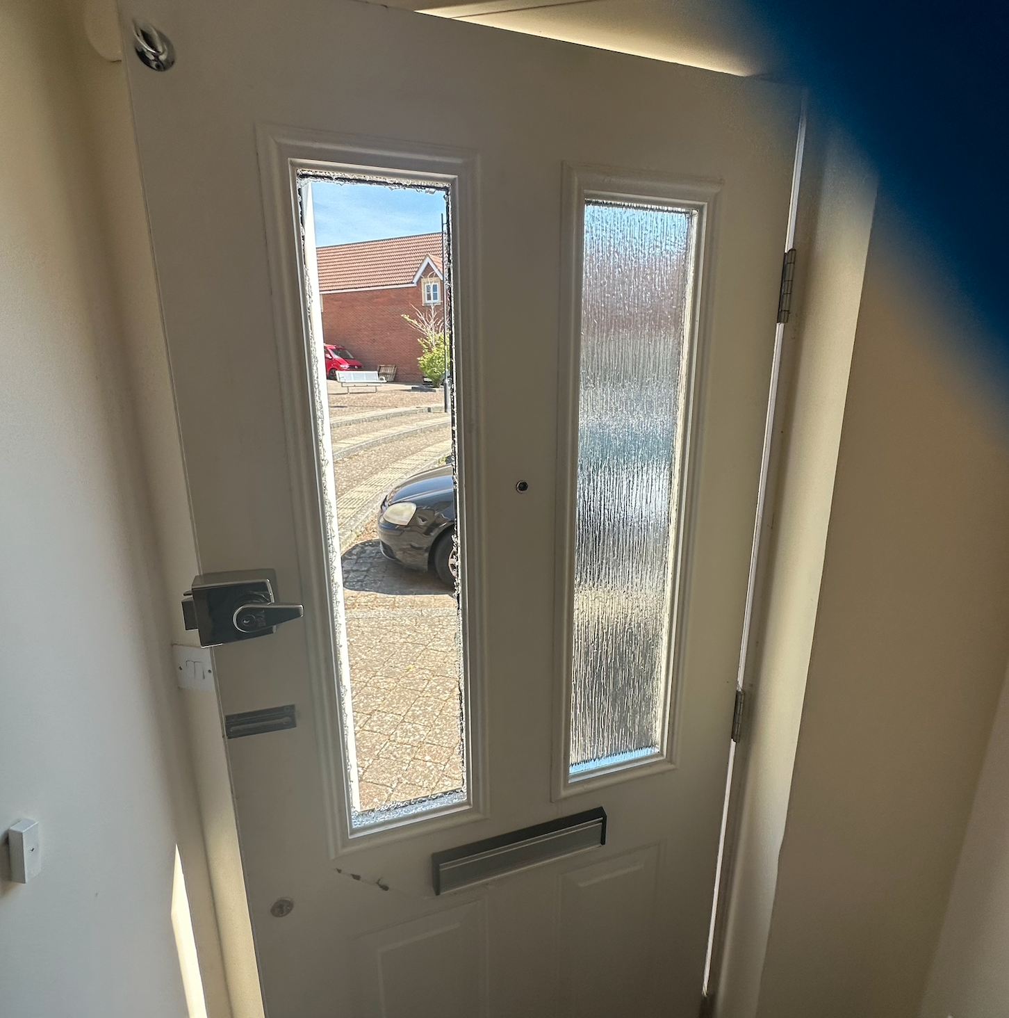 A composite door in which the double glazed glass within has been smashed.