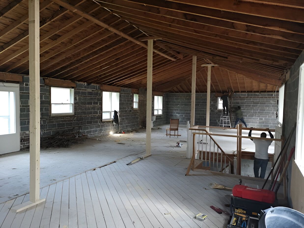 An empty room with a wooden ceiling and stairs