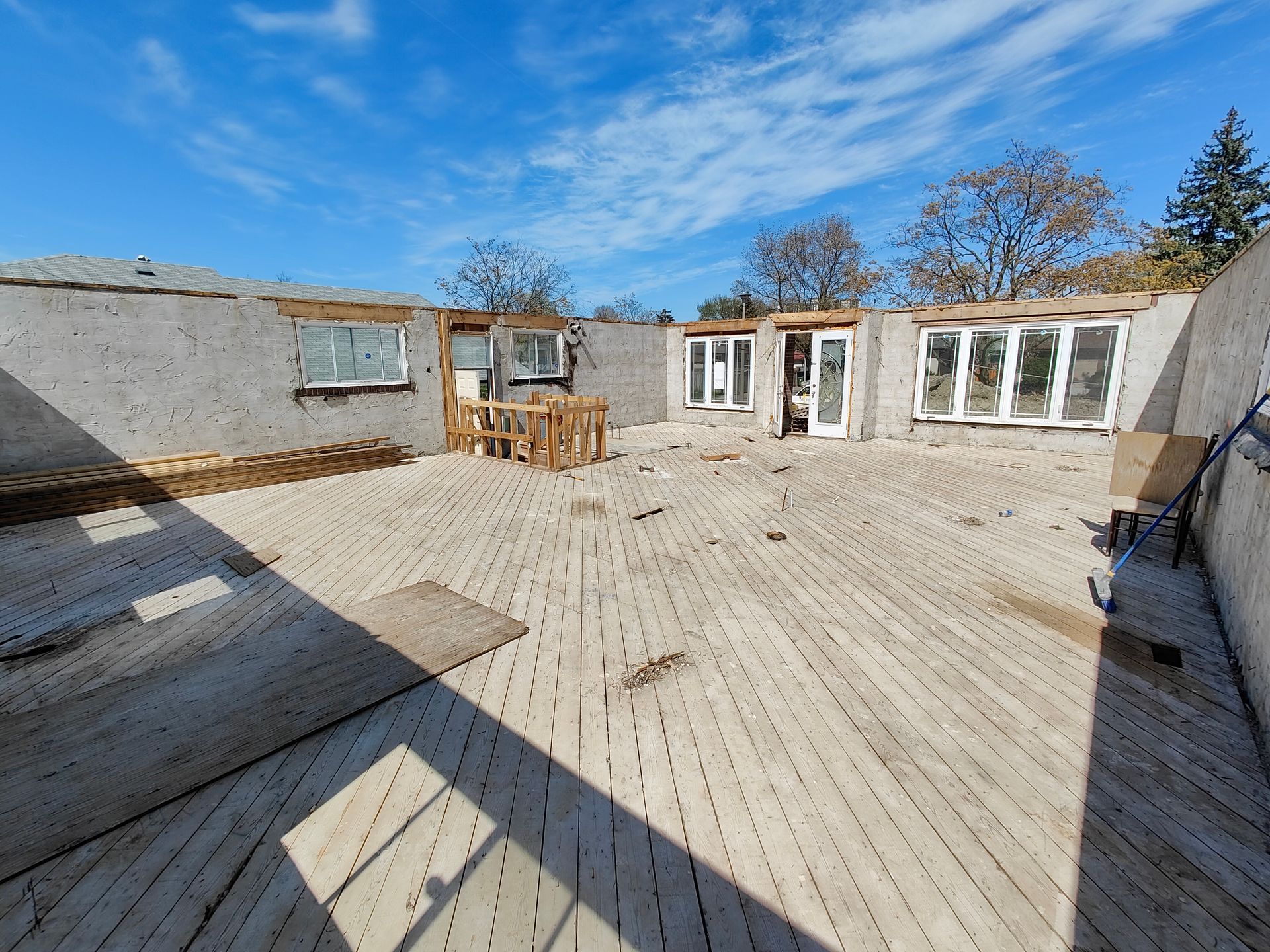 A wooden deck is being built in the backyard of a house.