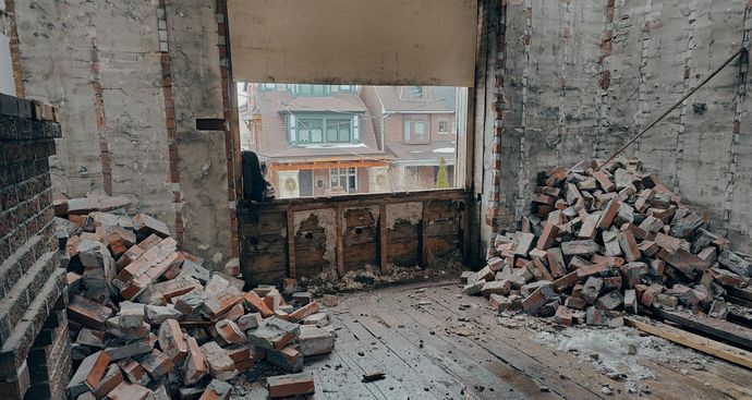 A room with a pile of bricks on the floor and a window.