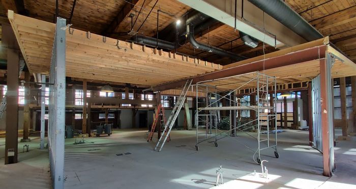 A large empty room with a wooden ceiling and scaffolding.