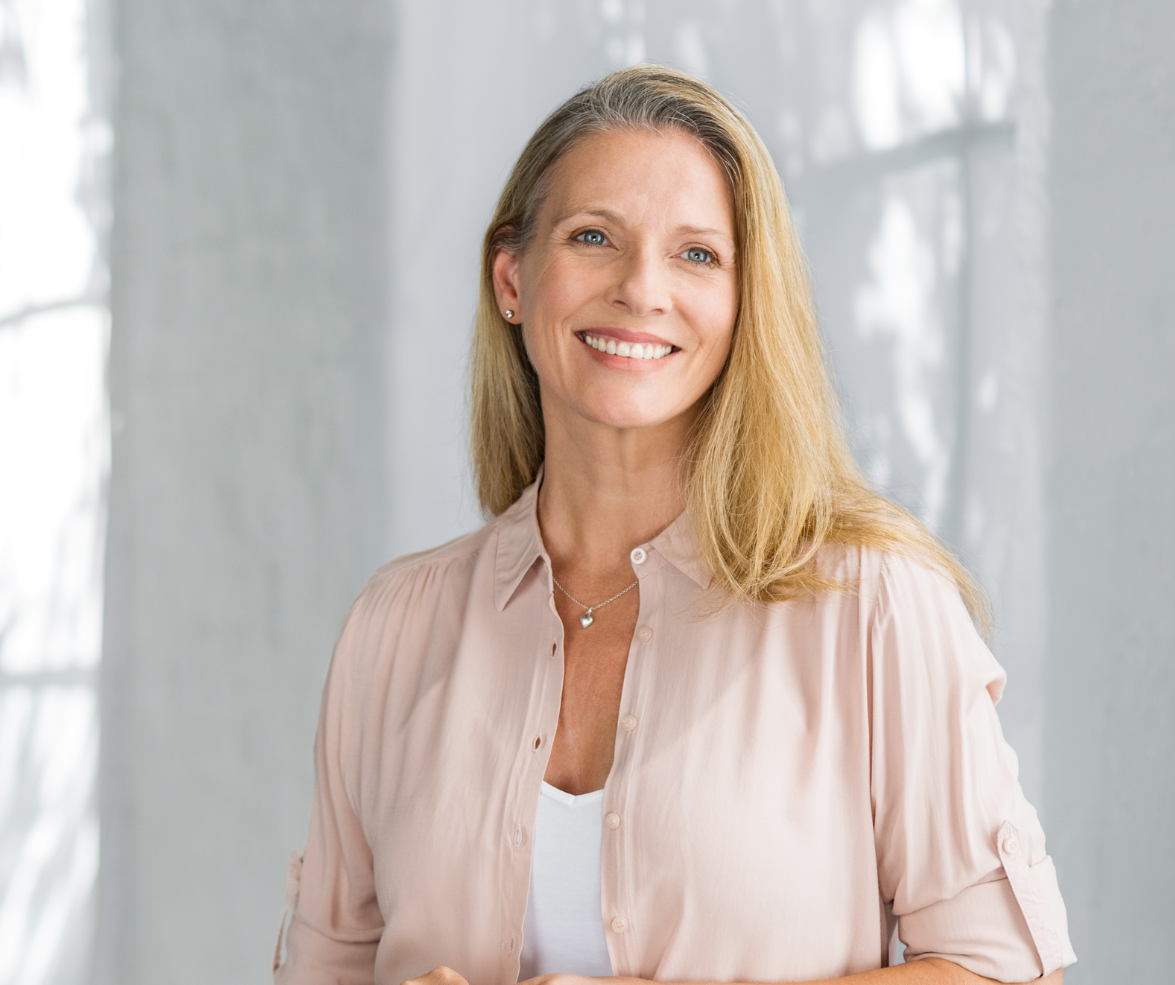 Smiling woman with blonde hair wearing a light pink blouse