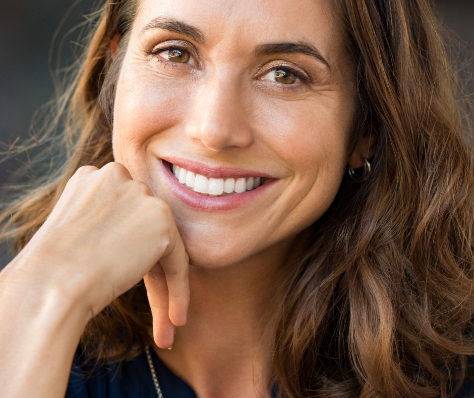 Woman with wavy brown hair smiling