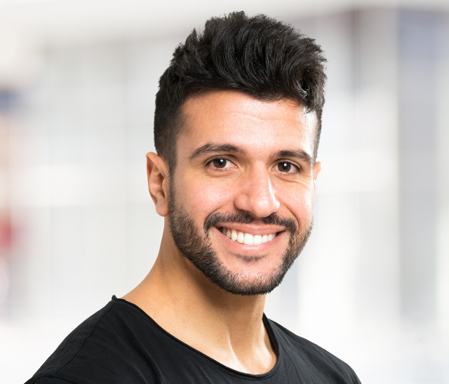 Man with short hair and a beard smiling