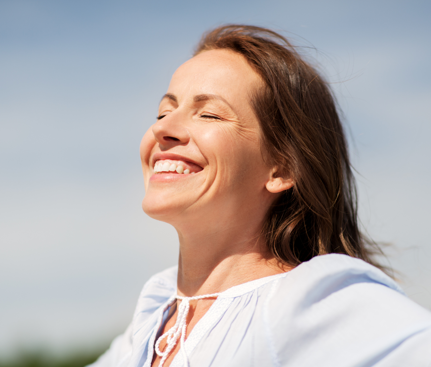 Woman smiling with her face turned toward the sun