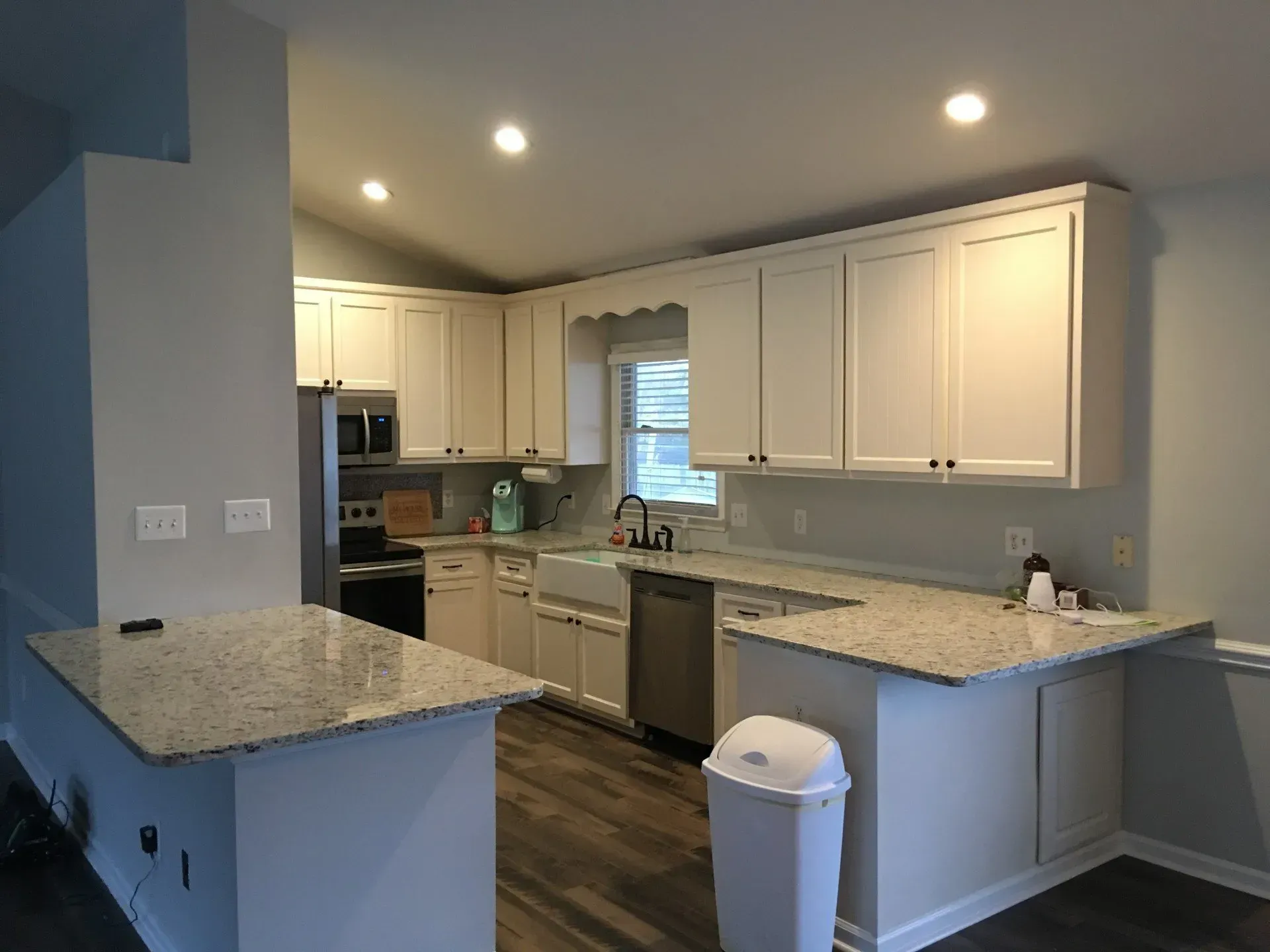 A kitchen with white cabinets and granite counter tops