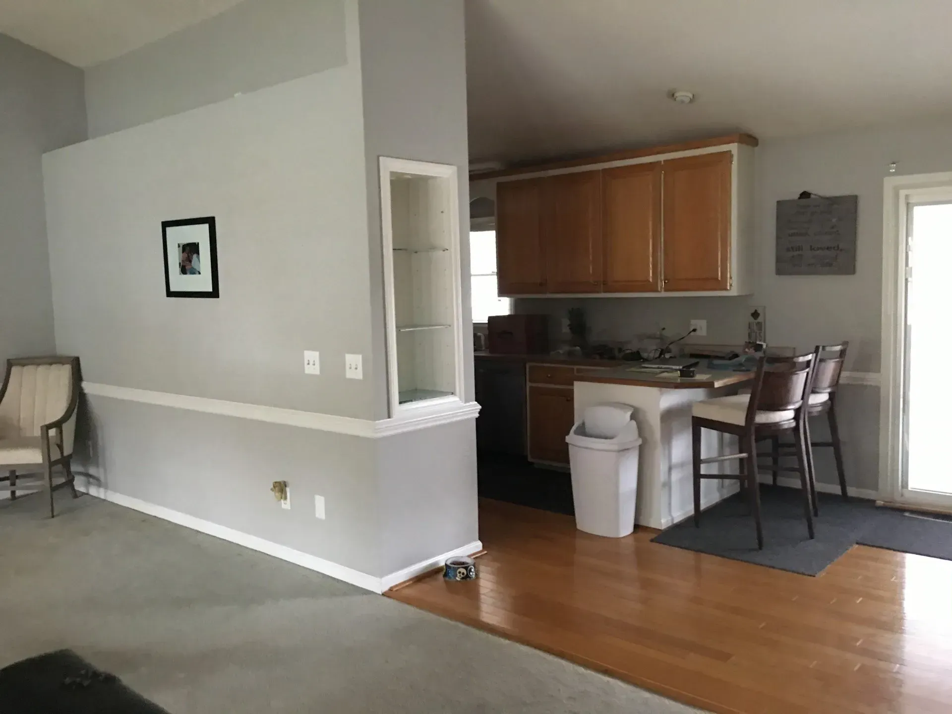 A living room and kitchen are connected by a sliding glass door.