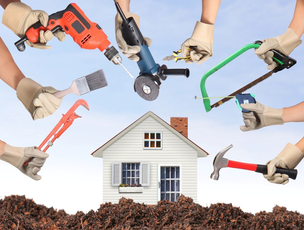 A group of people are holding tools in front of a house