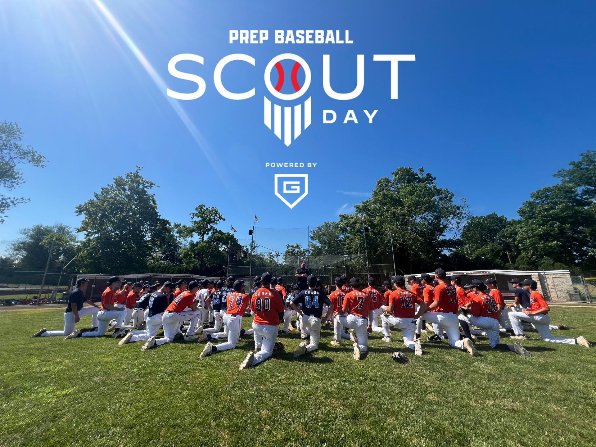 A group of baseball players are kneeling on a field for prep baseball scout day