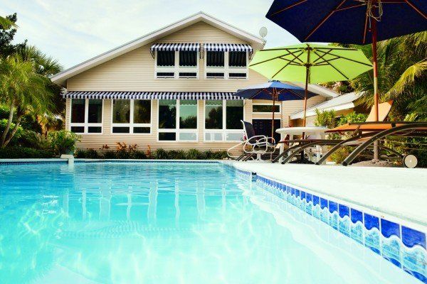 A large house with a swimming pool in front of it