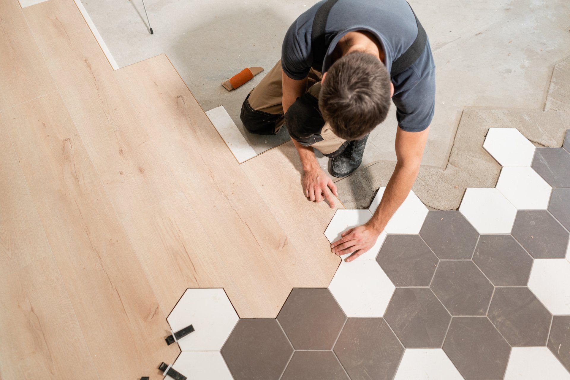 Male worker installing new wooden laminate flooring