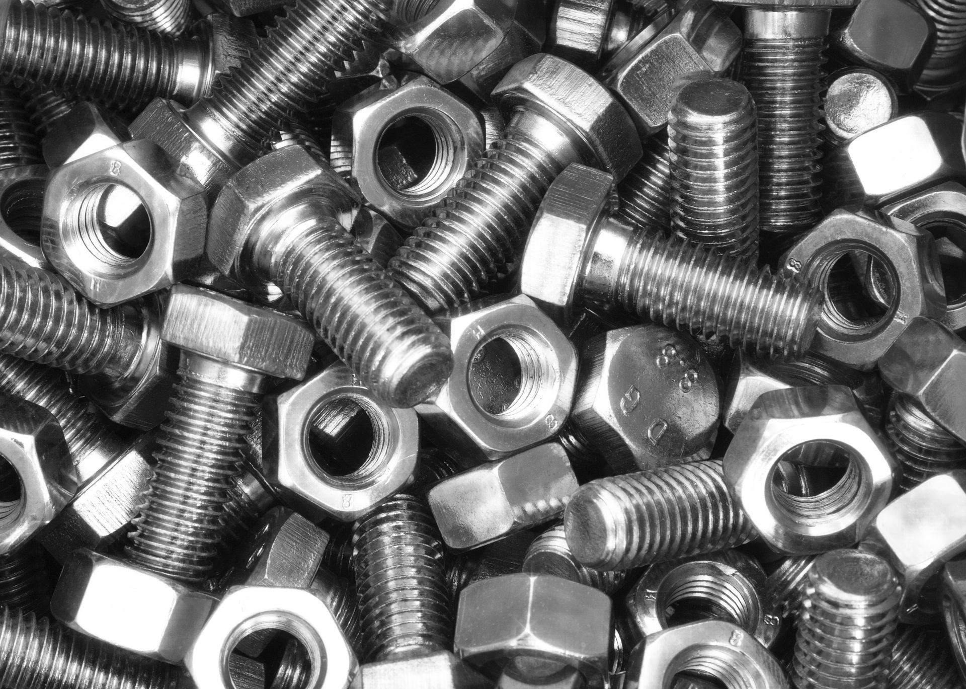 Pile of shiny metal bolts and nuts.