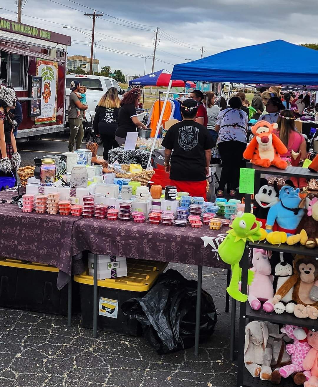 A group of people are gathered around a table with stuffed animals on it