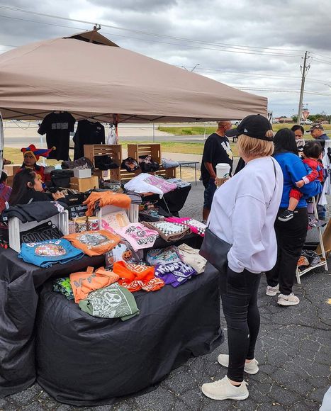 A group of people are standing around a table at a market.