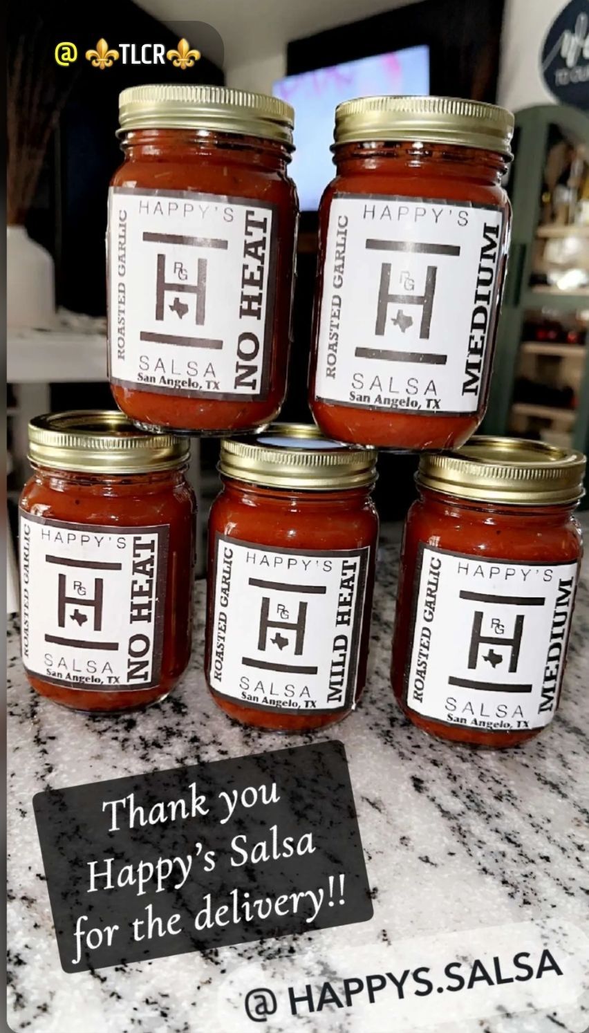 Several jars of salsa are stacked on top of each other on a counter.