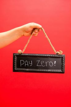 A person is holding a sign that says `` pay zero ''.