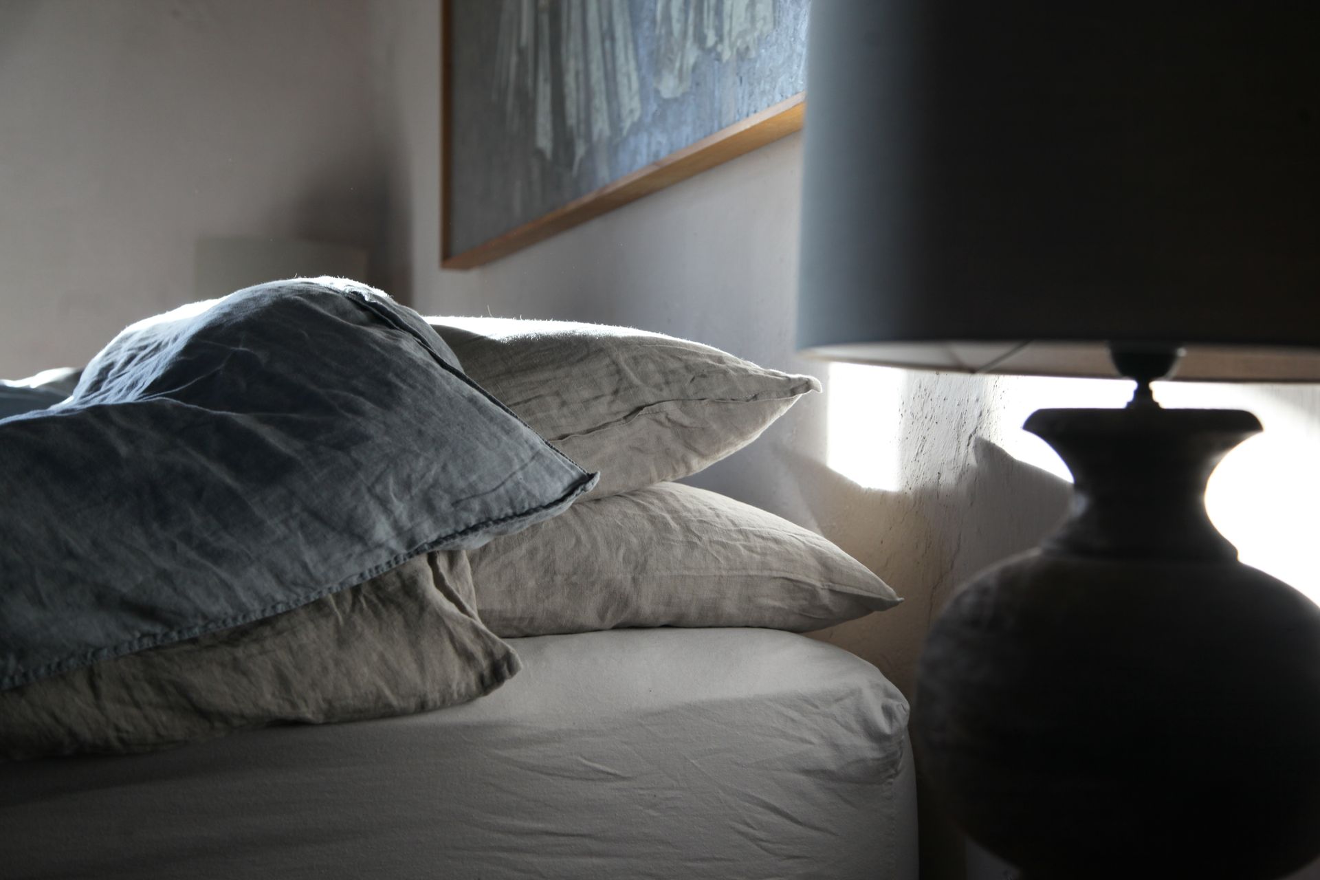 Nahaufnahme: Lampe (die am Nachttisch steht - den sieht man aber am Bild nicht) und Oberer Teil des Bettes mit Polster und Decke.