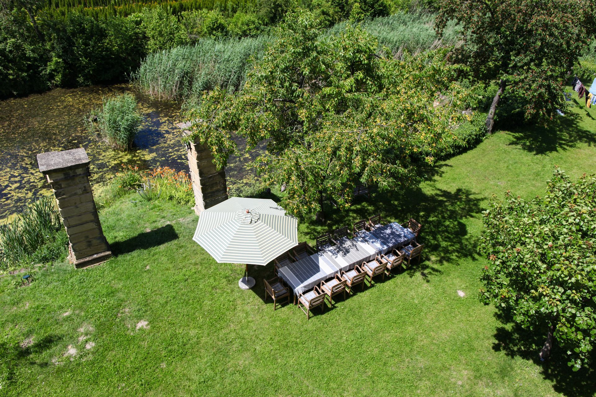 Garten von oben mit Tischen, Sessel und Sonnenschirm