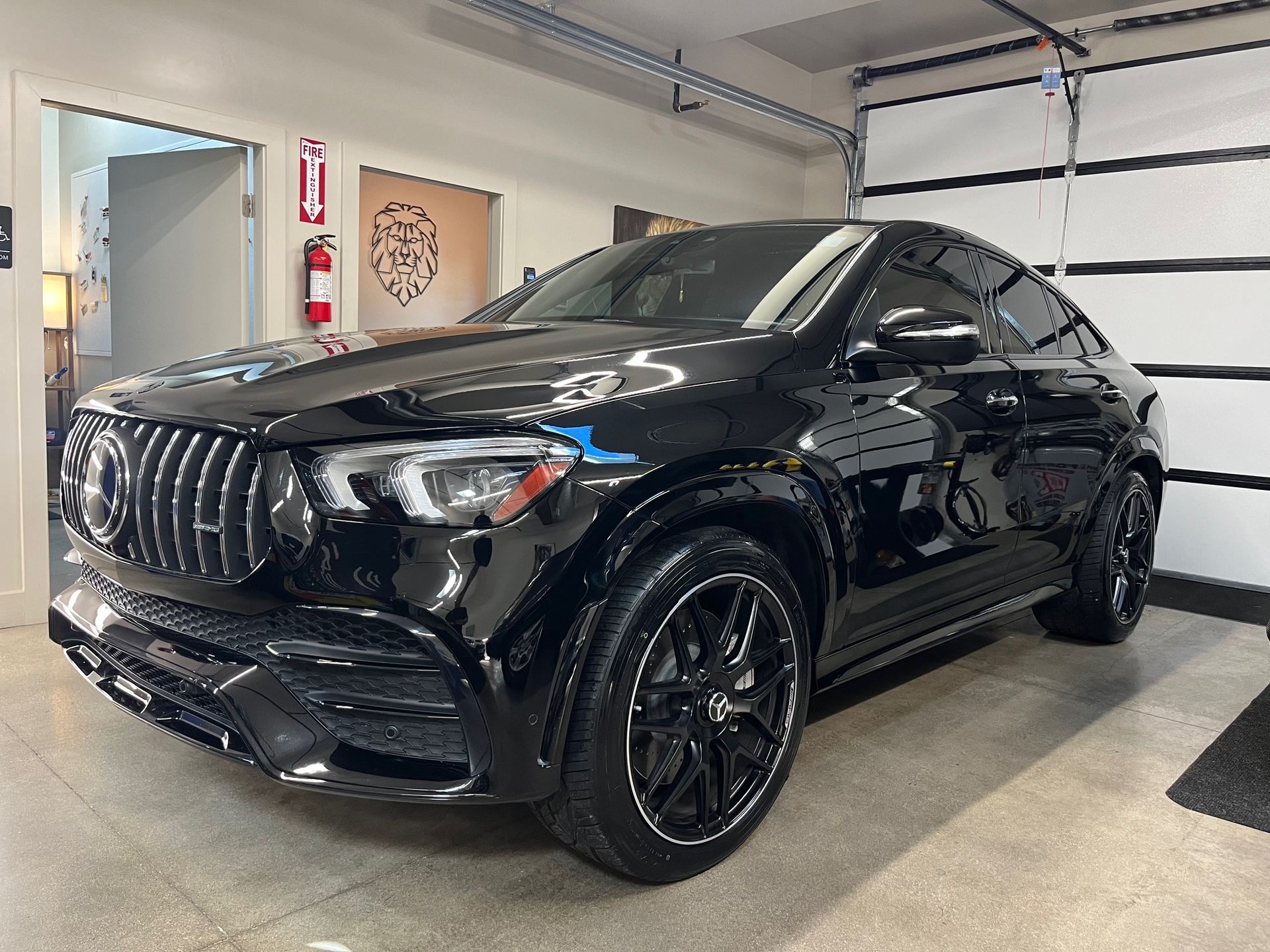 A black mercedes benz gle 63 amg is parked in a garage.