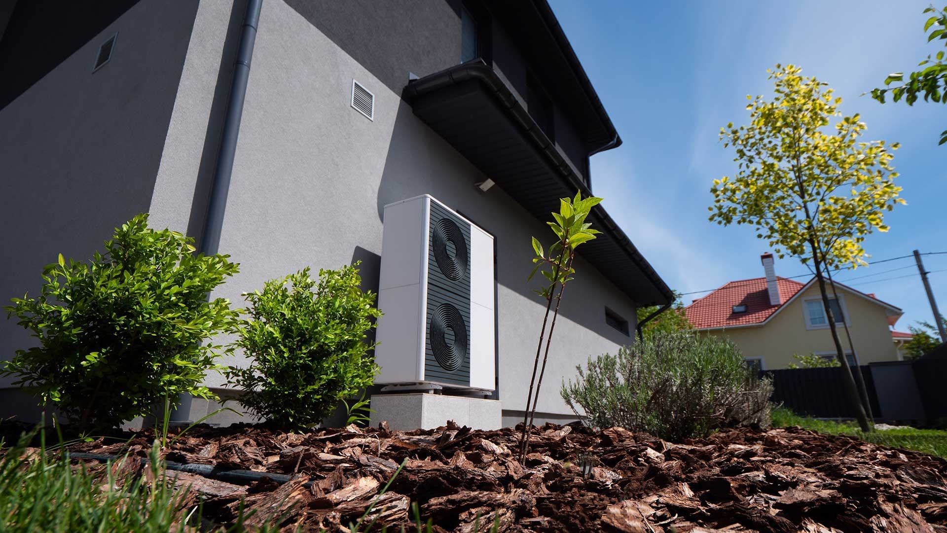 Et hus med et hvidt klimaanlæg på siden af det