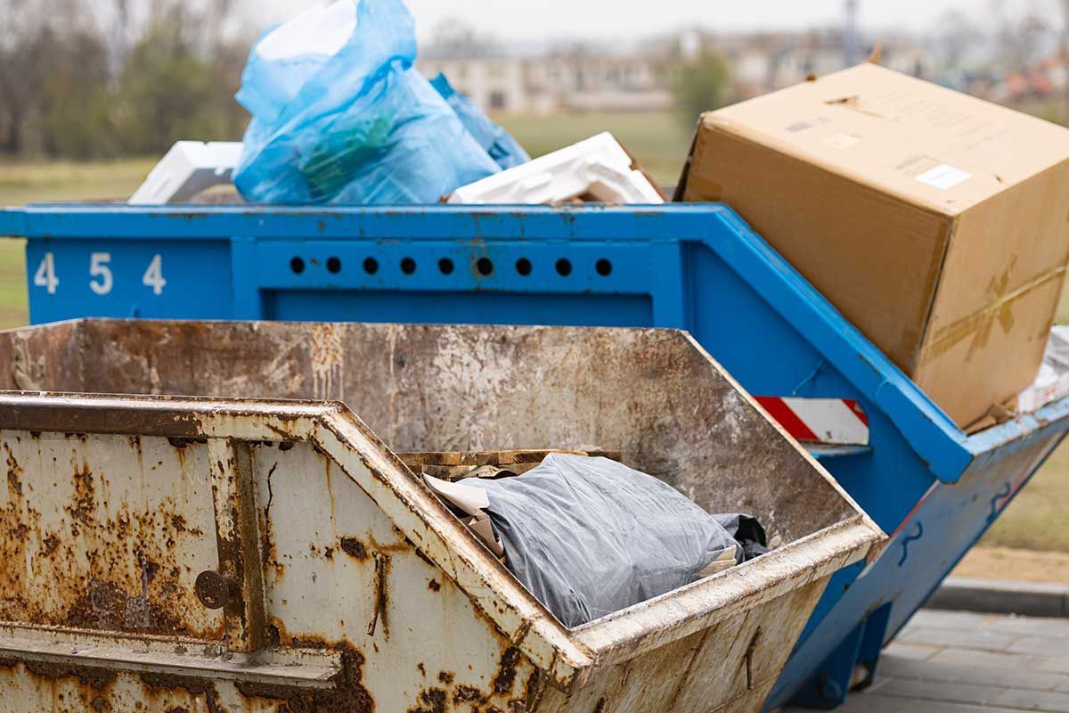 En skraldespand fyldt med affald og en kasse.