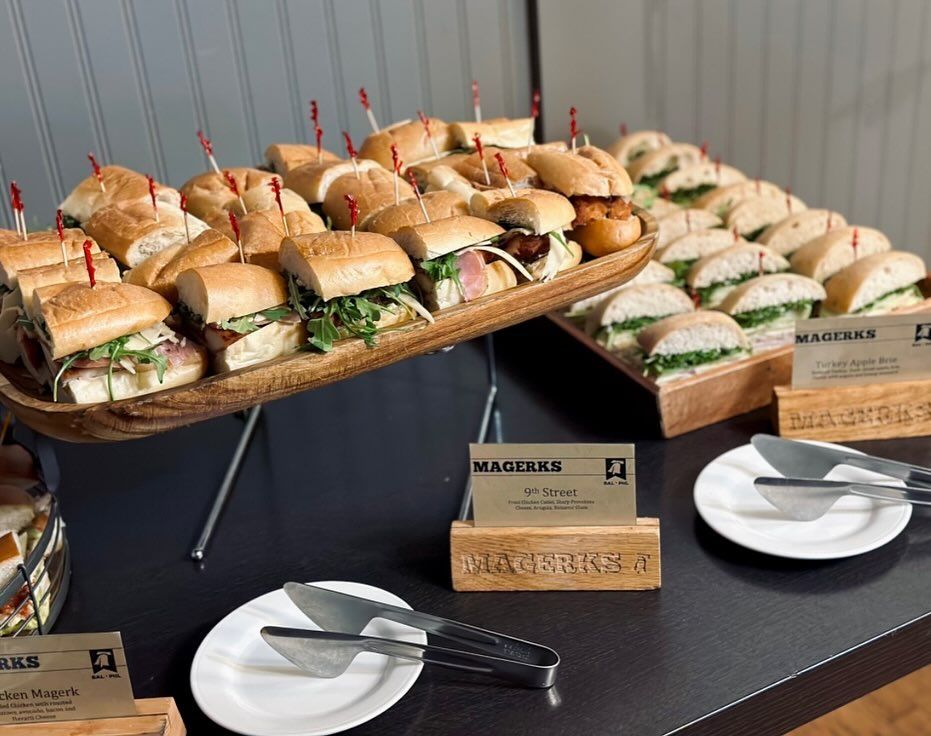 Slider burger with arugula, chips, cocktail, and beer on a wooden table.