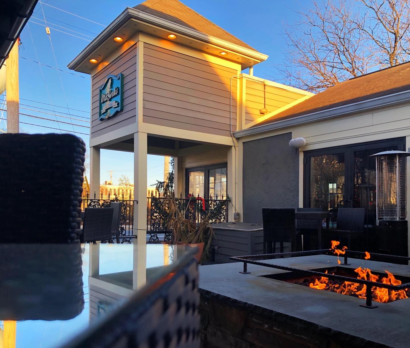 Busy sports bar with patrons eating and watching TVs. Servers walk among tables. Wooden bar and floors.