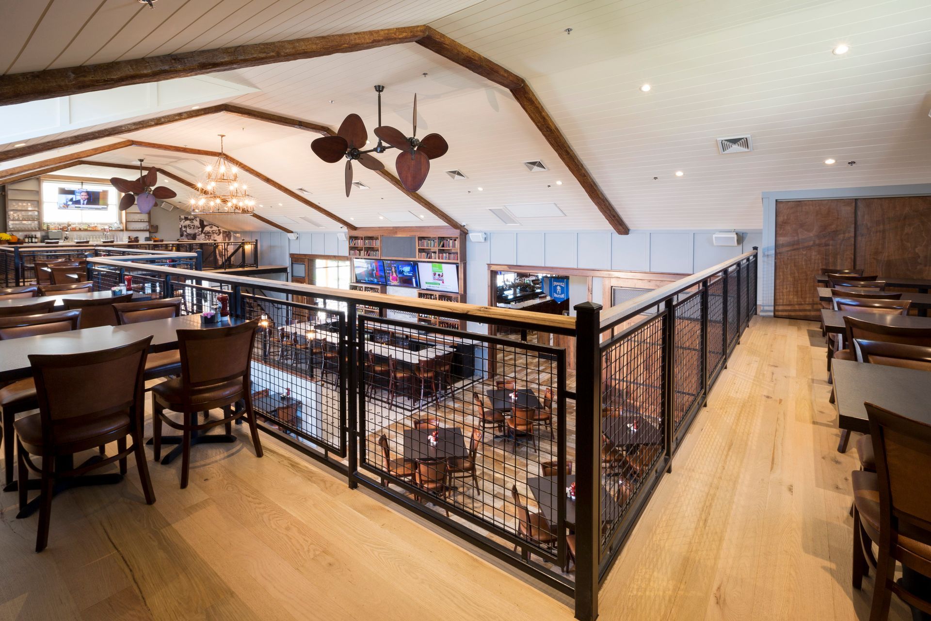 Slider burger with arugula, chips, cocktail, and beer on a wooden table.