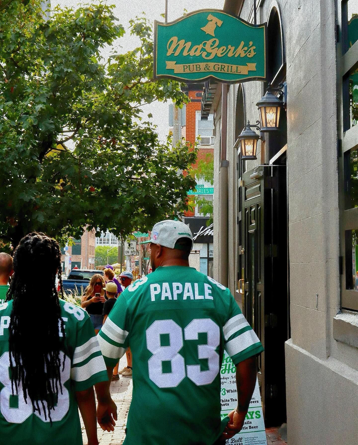 Busy sports bar with patrons eating and watching TVs. Servers walk among tables. Wooden bar and floors.