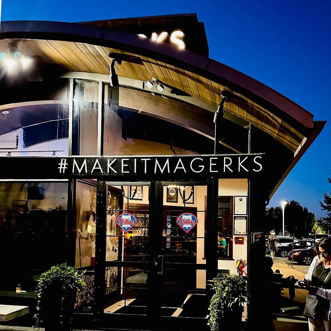 Interior of a crowded sports bar with tables, bar seating, TV screens, and servers carrying food.