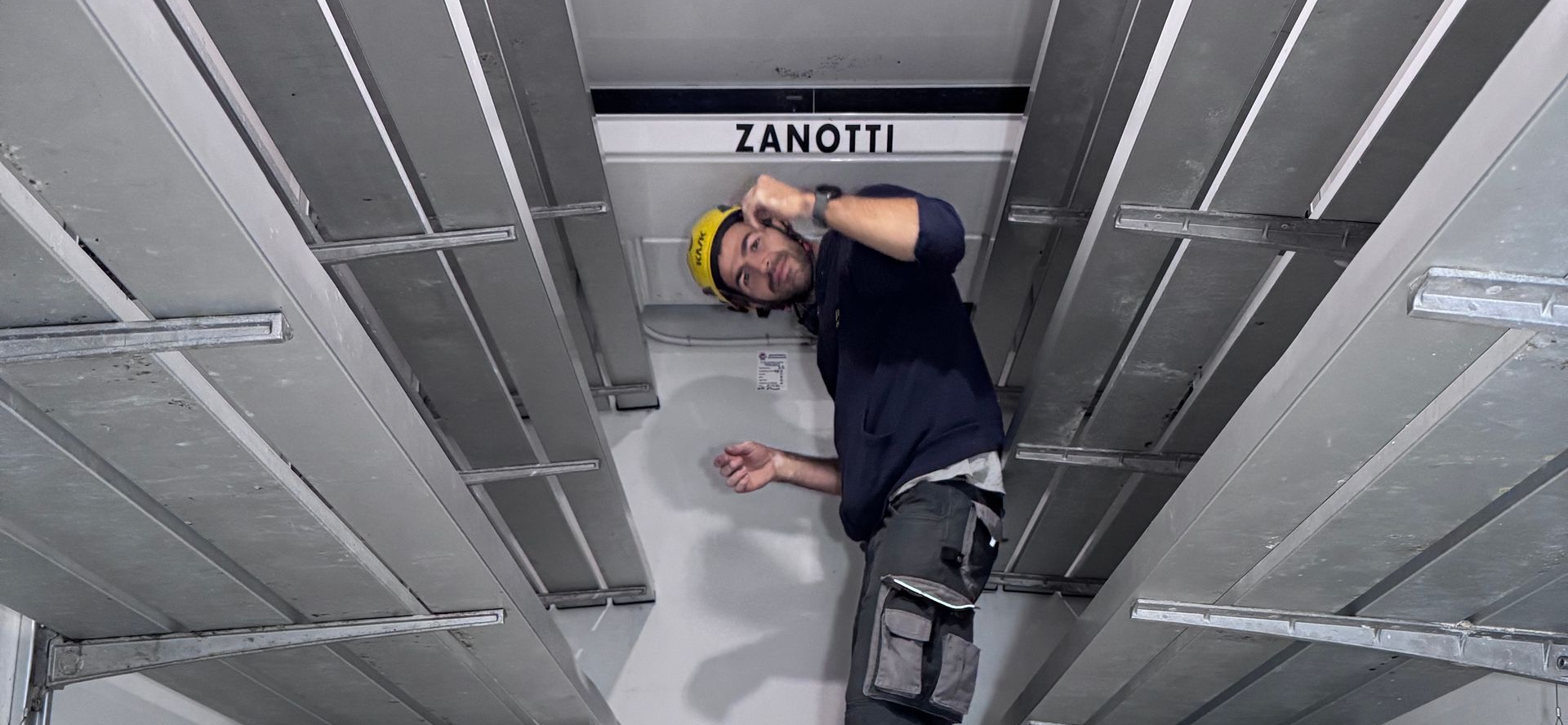 Un camion blu è parcheggiato accanto a un camion bianco in un parcheggio.